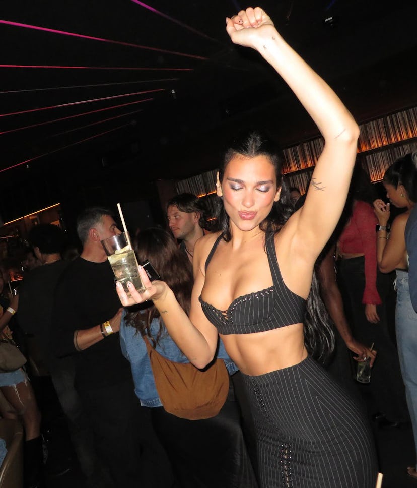 Dua Lipa wore a plunging pinstripe bra and matching lace-up skirt.