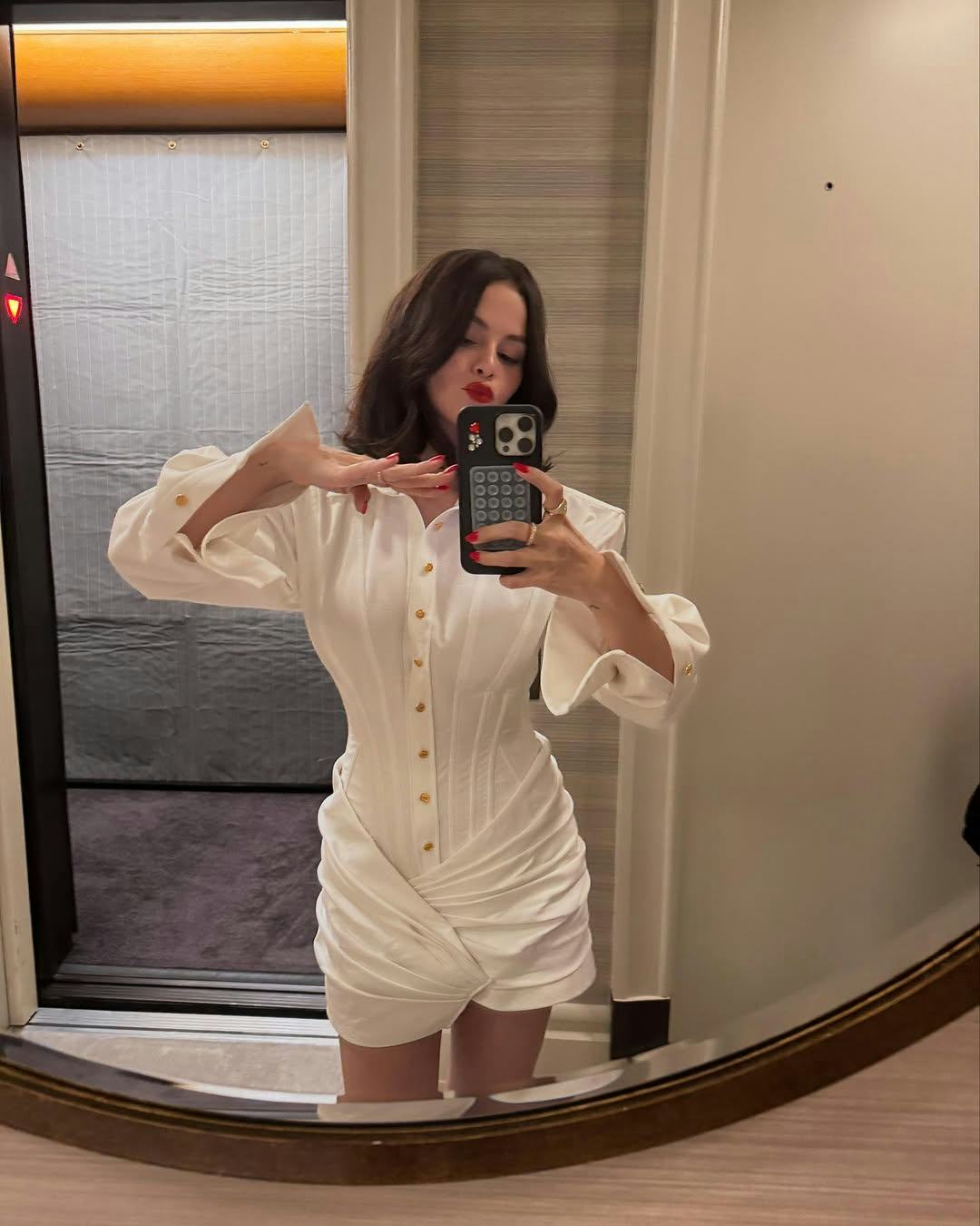Selena Gomez wears a white button-down minidress.
