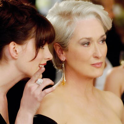 Screen grab of Anne Hathway as Andie whispering in Miranda Priestley's ear, from The Devil Wears Prada