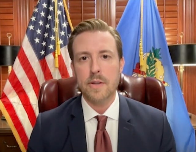Oklahoma State Superintendent Ryan Walters, pictured from the chest up wearing a suit and sitting in...