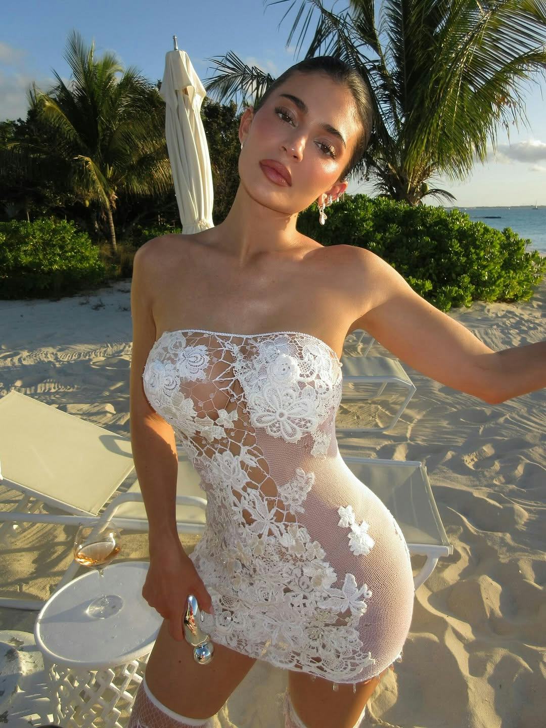 Kylie Jenner wears a see-through white dress.