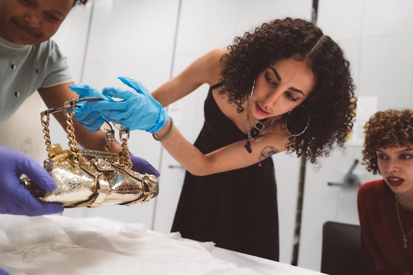A museum patron looking at a bag from the archival collection at the V&A’s Easy Storehouse