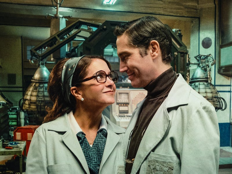 A smiling couple in lab coats share a warm gaze in a vintage laboratory setting, filled with equipme...
