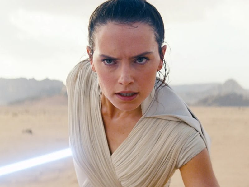 A determined character in a light-colored outfit stands in a desert landscape, wielding a glowing li...