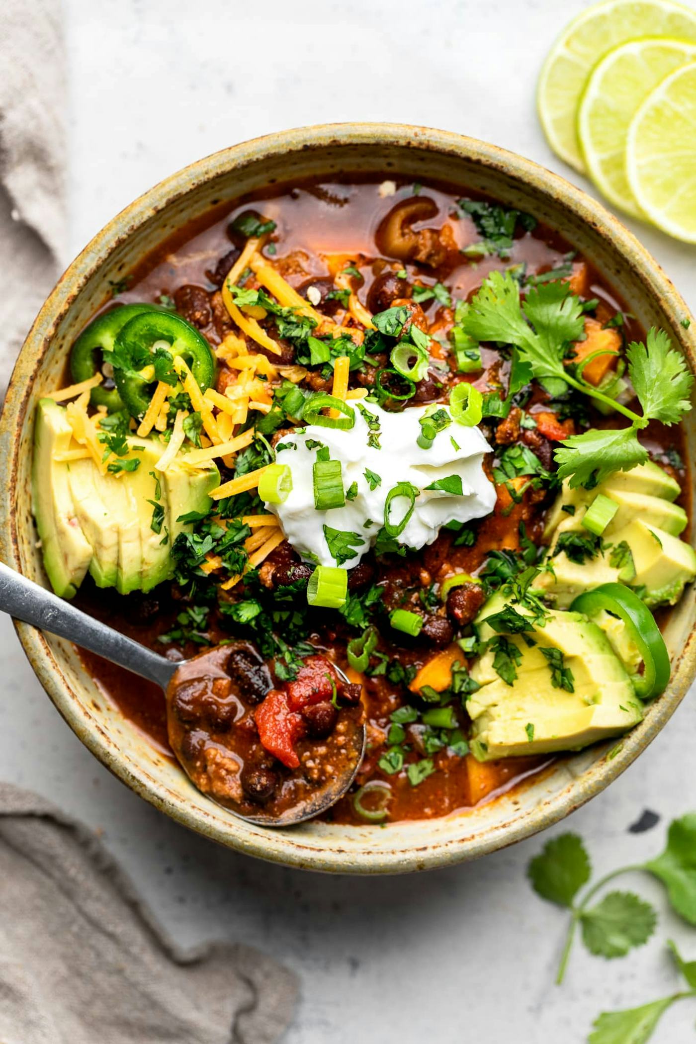 Sweet potato and black bean chili with cilantro and sour cream on top, in a story about black bean recipes