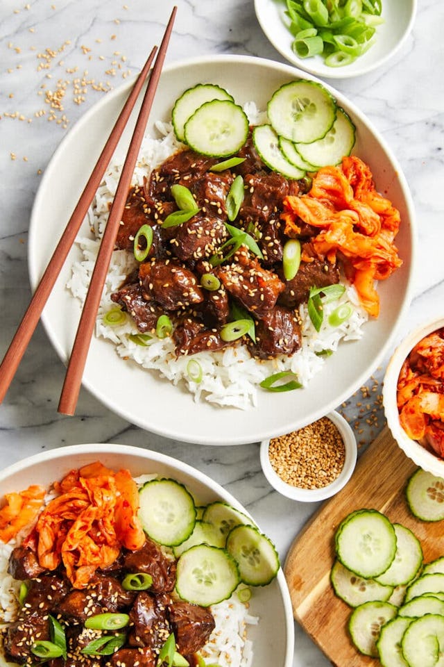 Slow cooker Korean beef in a bowl with rice and cucumbers, in a story about chuck roast recipes.