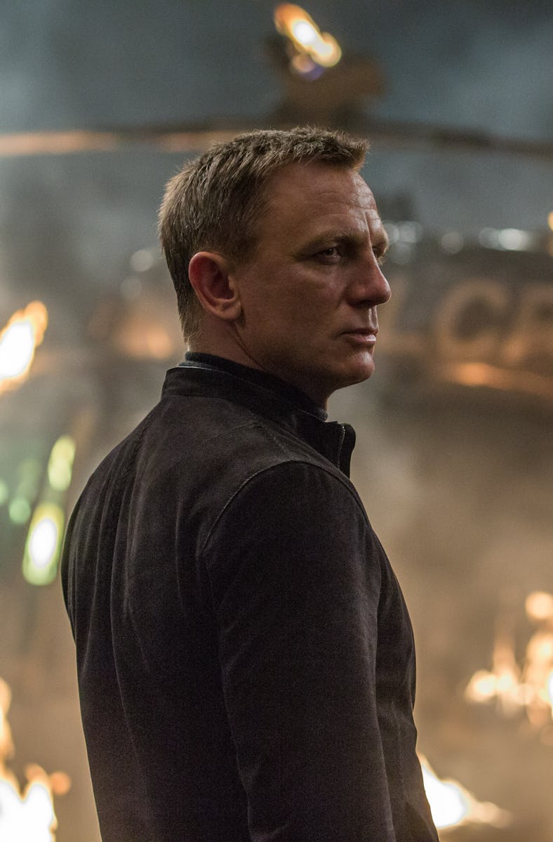 A man with short hair stands confidently against a backdrop of flames and smoke, suggesting a dramat...