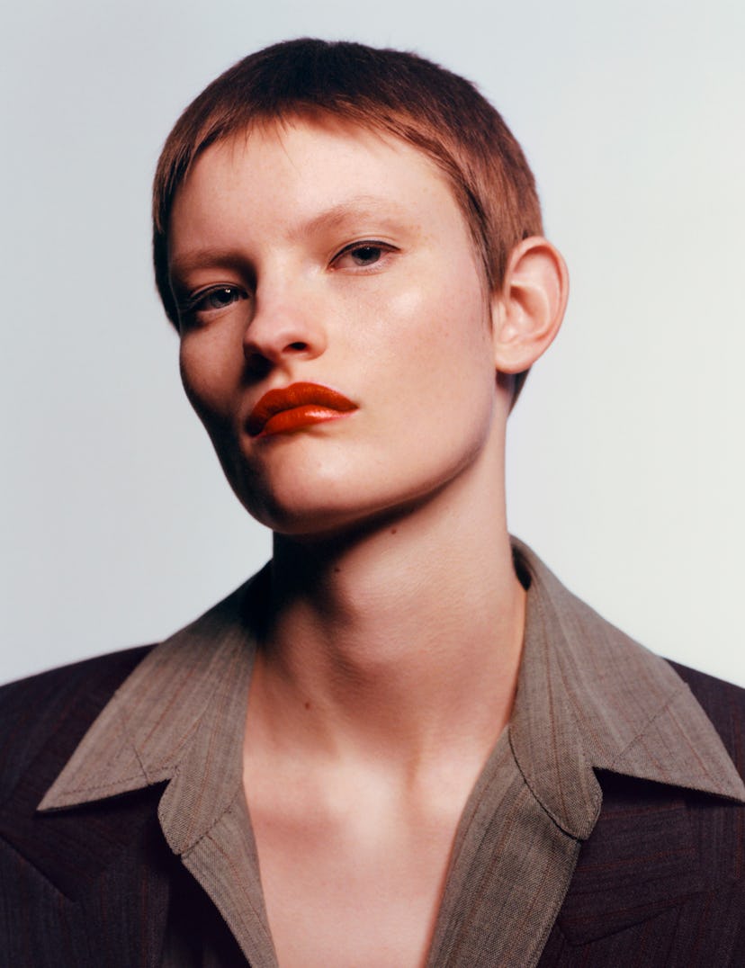 a model with a ginger pixie cut and pouty look on their face
