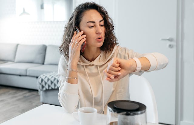 Woman at home looking at watch