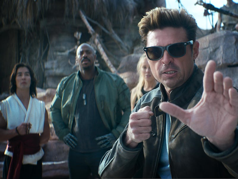 A group of four people stands in a rocky outdoor setting. One man in the foreground, wearing sunglas...
