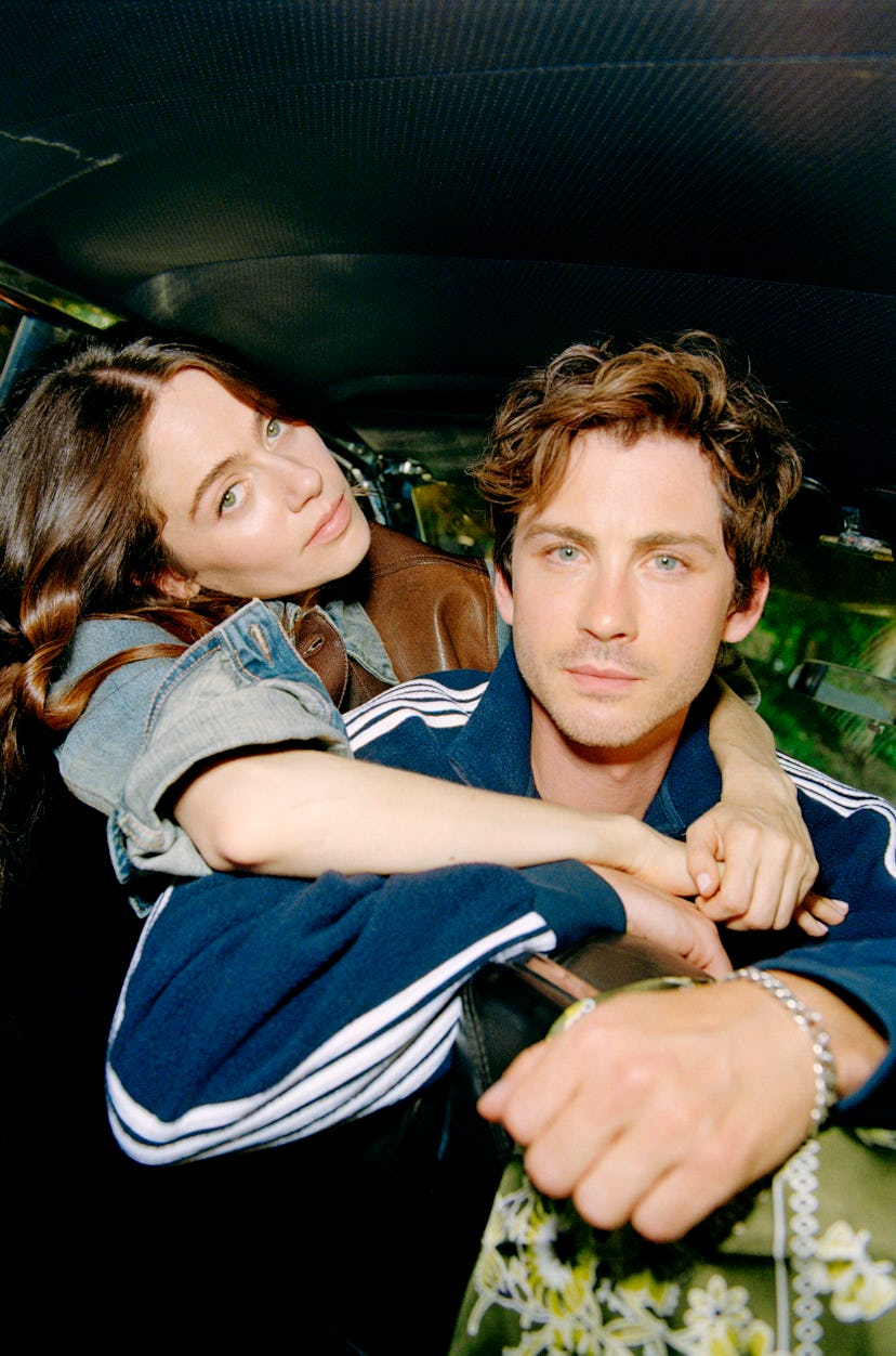 Molly Gordon and Logan Lerman embrace in a vintage car