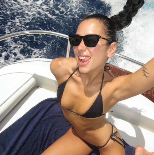 Dua Lipa wears a black bikini.