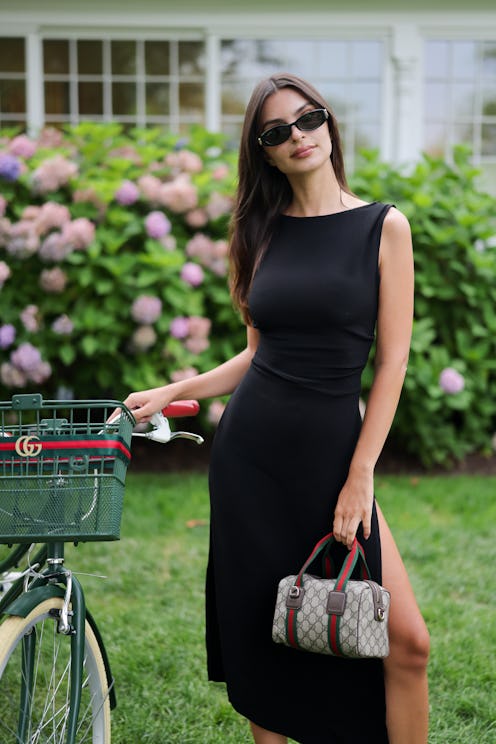 Emily Ratajkowski wears a black dress and Gucci bag.