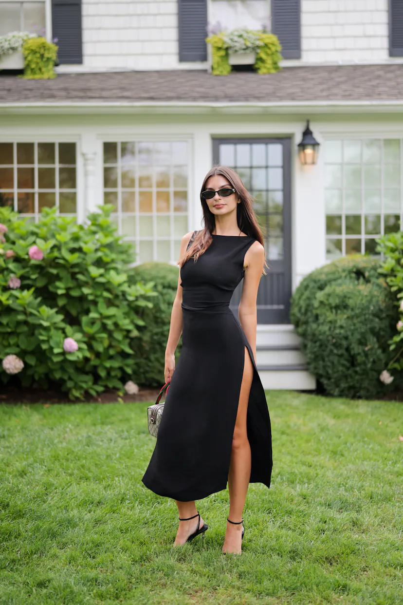 Emily Ratajkowski wears a black dress and Gucci bag.