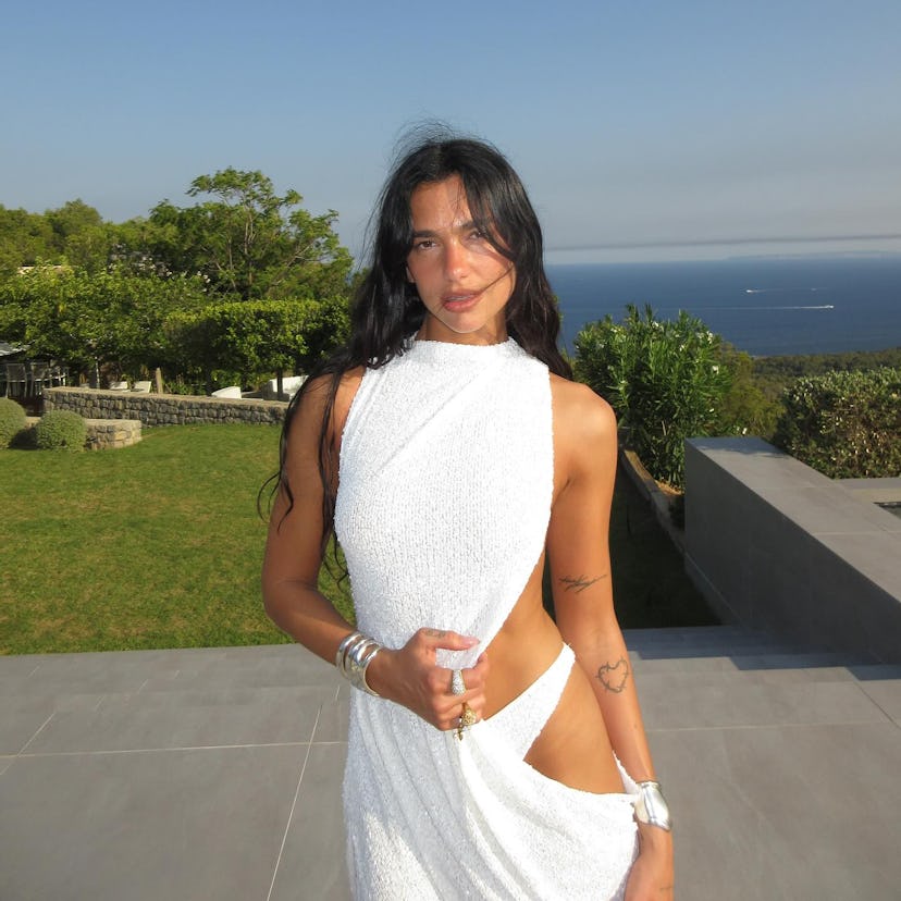 Dua Lipa wears a white sequined cutout dress.