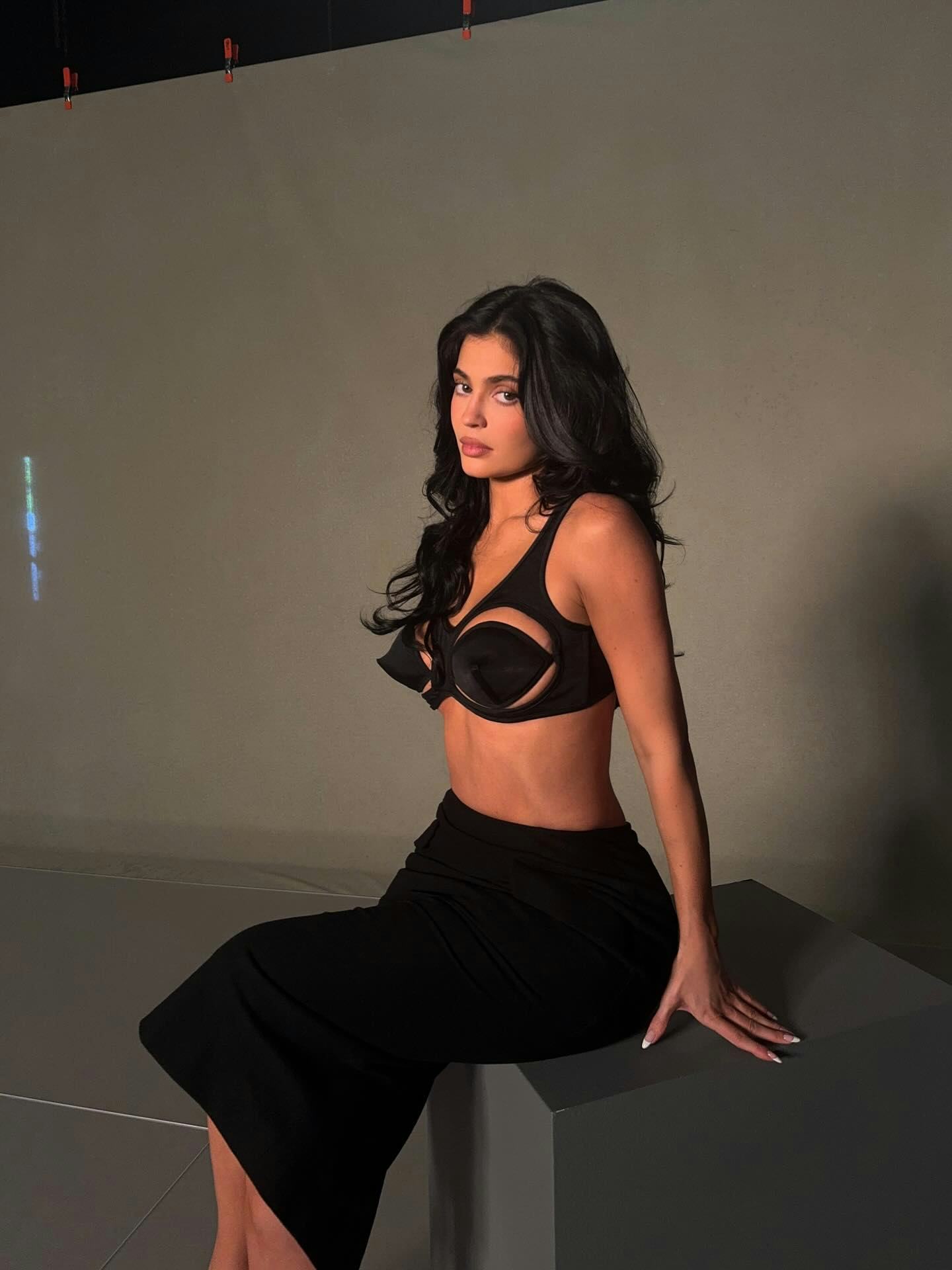 Kylie Jenner wears a bra and pencil skirt. 