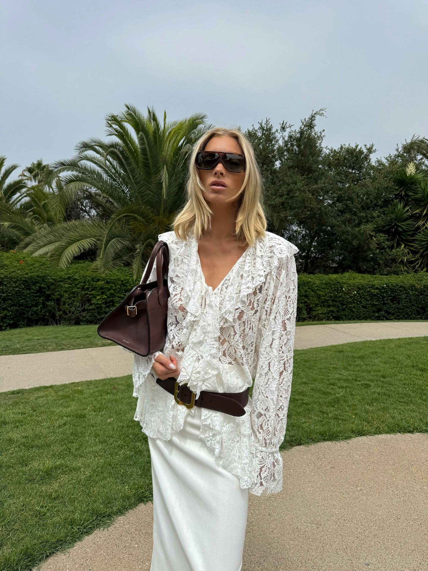 Elsa Hosk wears a lace top and a white skirt.