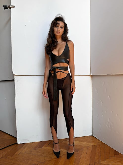 Emily Ratajkowski wears a plunging top and sheer pants.