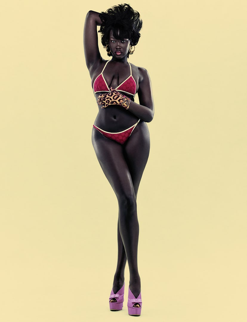 a model wearing a red swimsuit against a yellow background