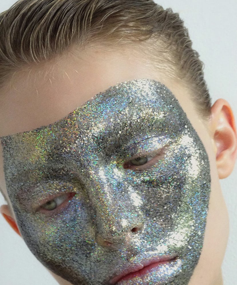 a person with silver glittery artfully applied in a mask shape over their face