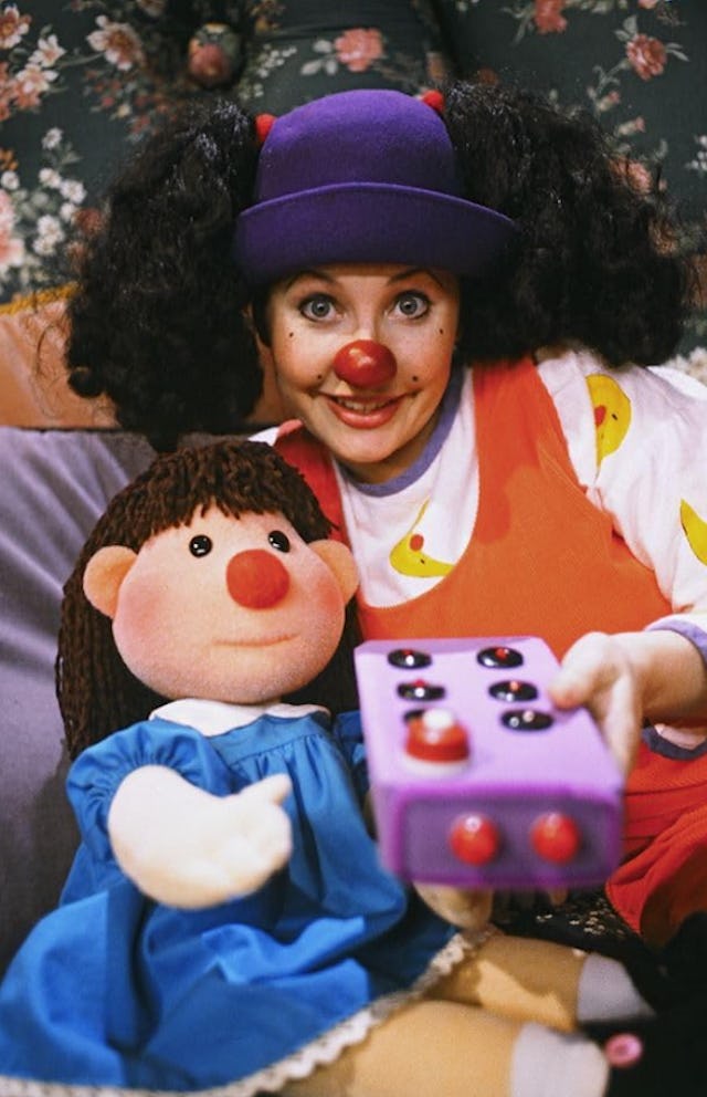 Loonette and molly sit with a big toy remote in a still from the big comfy couch.