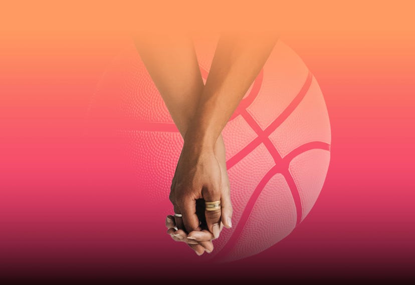 couple holding hands in front of a basketball.