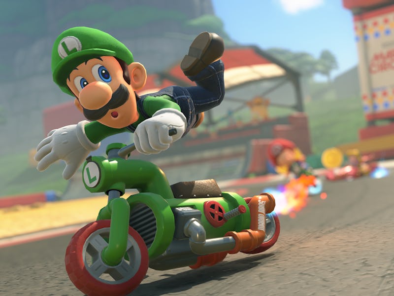 Luigi rides a motorbike on a colorful racetrack, leaning to one side. Other racers and golden coins ...