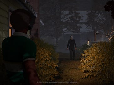 Michale Myers stands at the edge of a shrub-lined path, looking toward another figure walking toward...