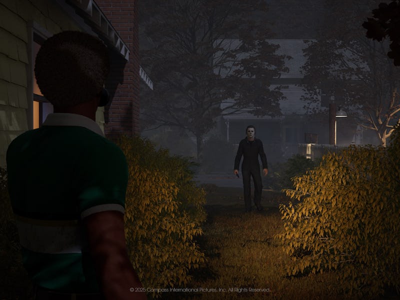 Michale Myers stands at the edge of a shrub-lined path, looking toward another figure walking toward...