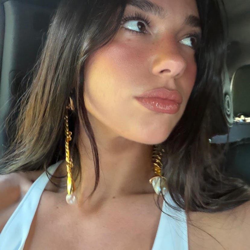 Dua Lipa wears a white dress.