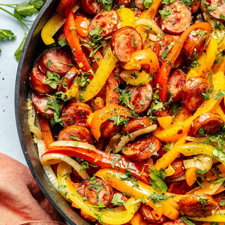 sausage and bell peppers in skillet in a story about quick and easy kielbasa recipes