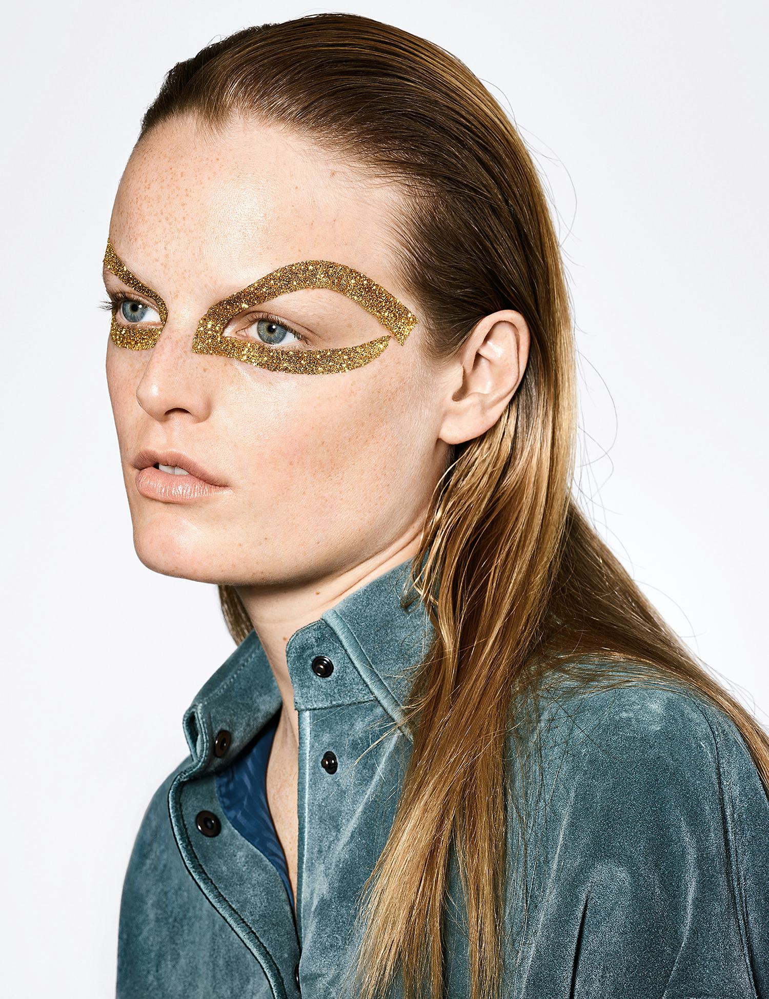 A model with gold sparkly glitter around her eyes