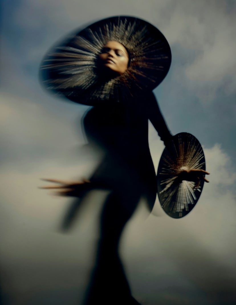 Zendaya in black dress with golden circles at her head and wrists.