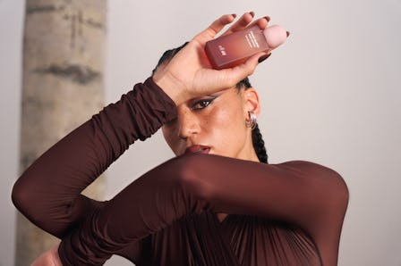 A model holds a bottle from the H&M x e.l.f. Beauty fragrance collaboration