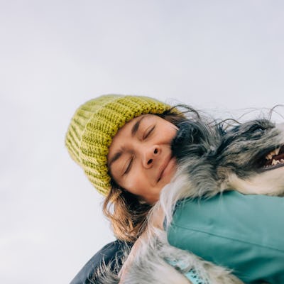 A woman hugs her dog.