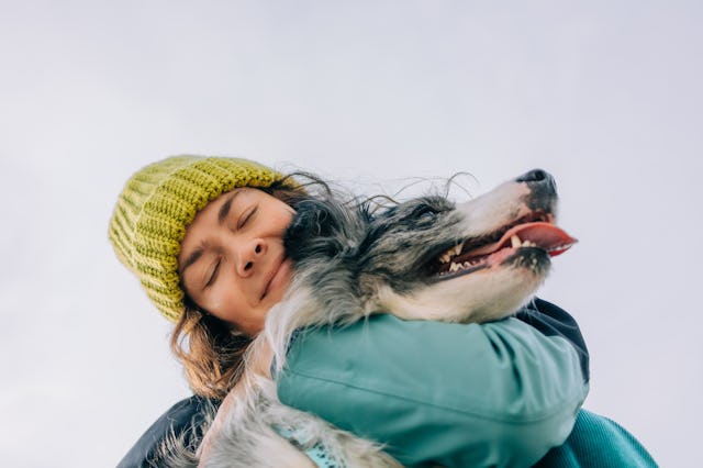 A woman hugs her dog.
