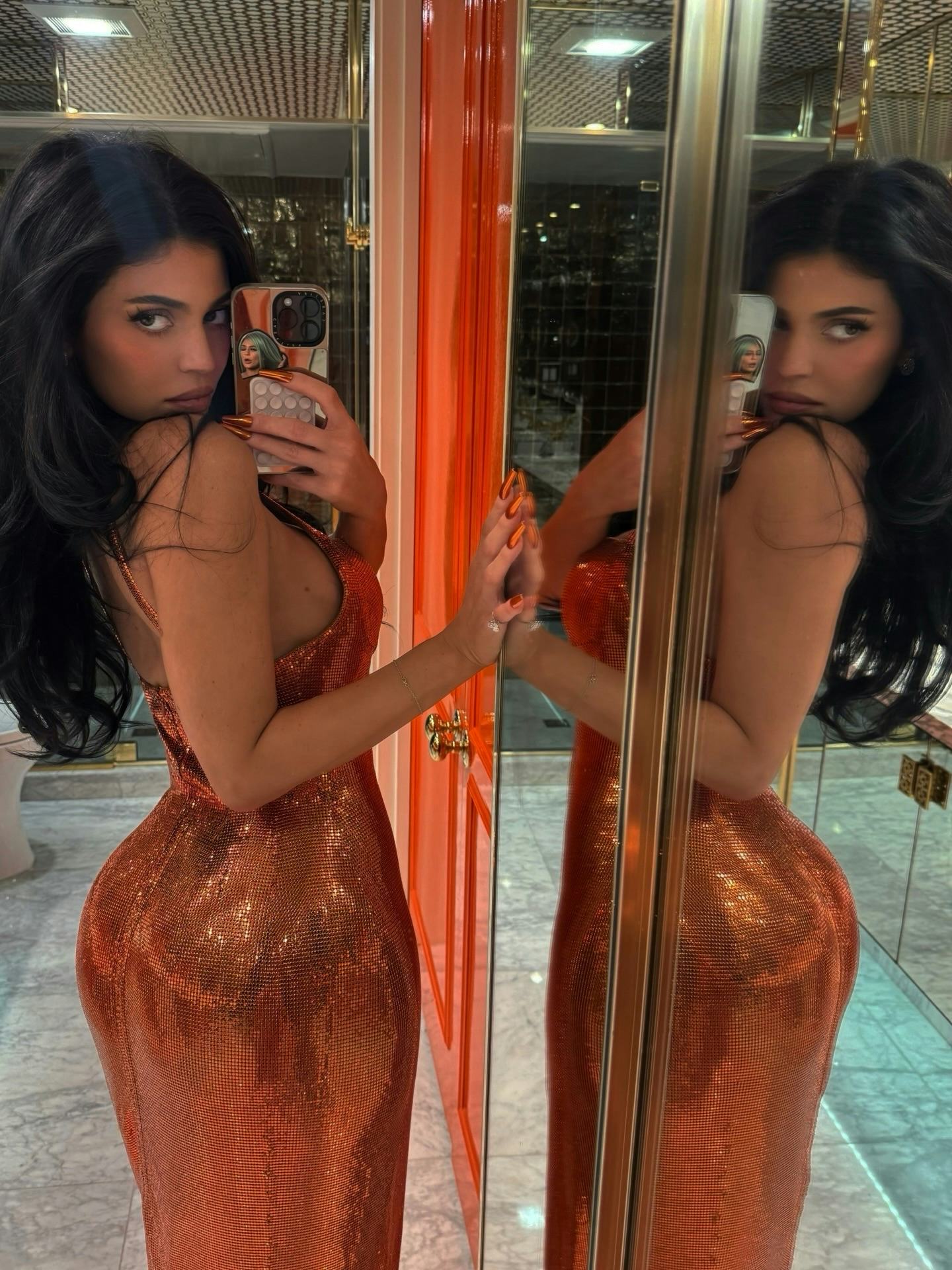 Kylie Jenner wears an orange metal mesh dress.  