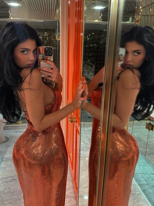Kylie Jenner wears an orange metal mesh dress.