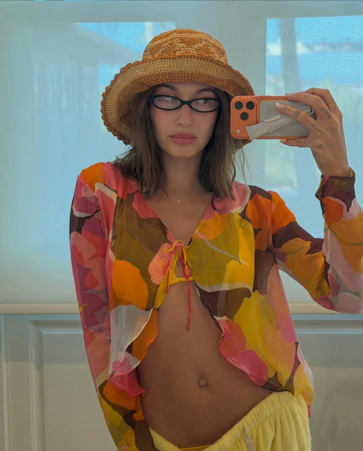 Hailey Bieber wears a yellow bikini and ruffled bolero. 