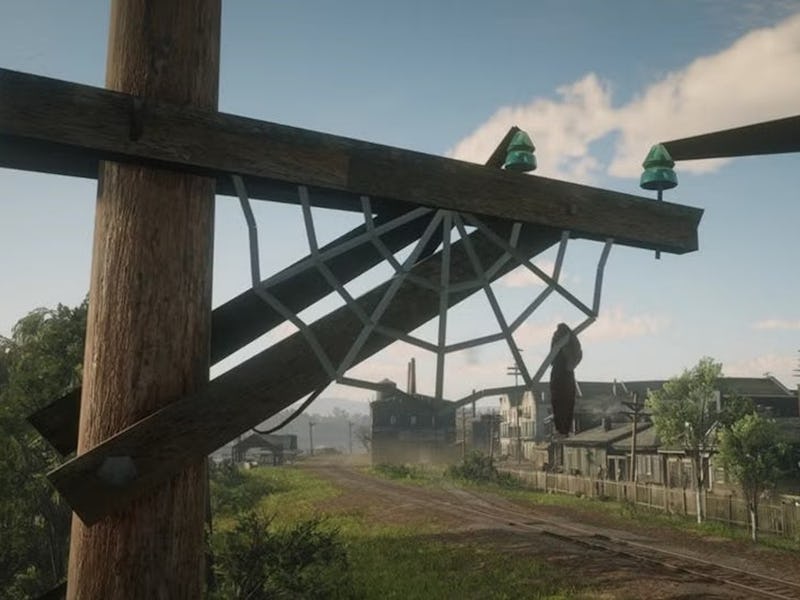 A damaged wooden utility pole with broken crossbeams and green glass insulators stands beside a dirt...