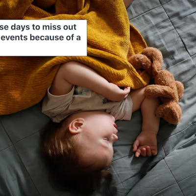 A toddler sleeps on a bed, wrapped in an orange blanket.