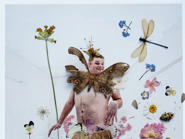 Joe Sweeney as a fairy with insects and flowers.