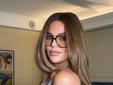 Khloe Kardashian wearing sunglasses in a hotel room, in a selfie