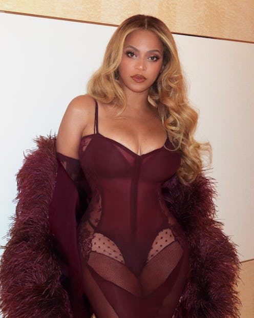 Beyoncé in a wine-colored dress with long, bouncy blonde hair