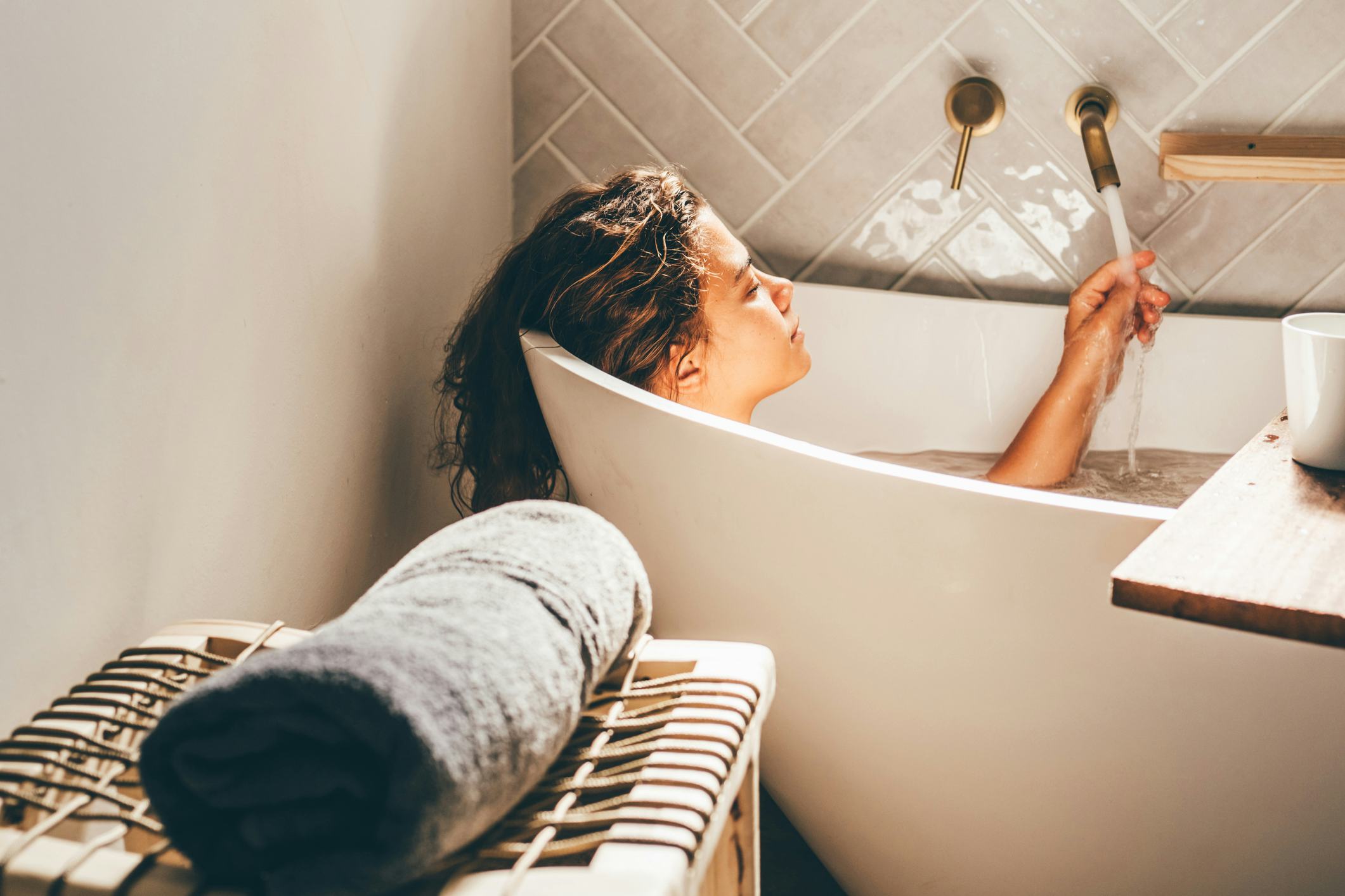 Young woman relaxing in bath tub. Self care and mental health concept. 
