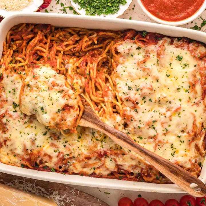 baked spaghetti surrounded by breadsticks and salad, a great recipe if you need kid dinner ideas