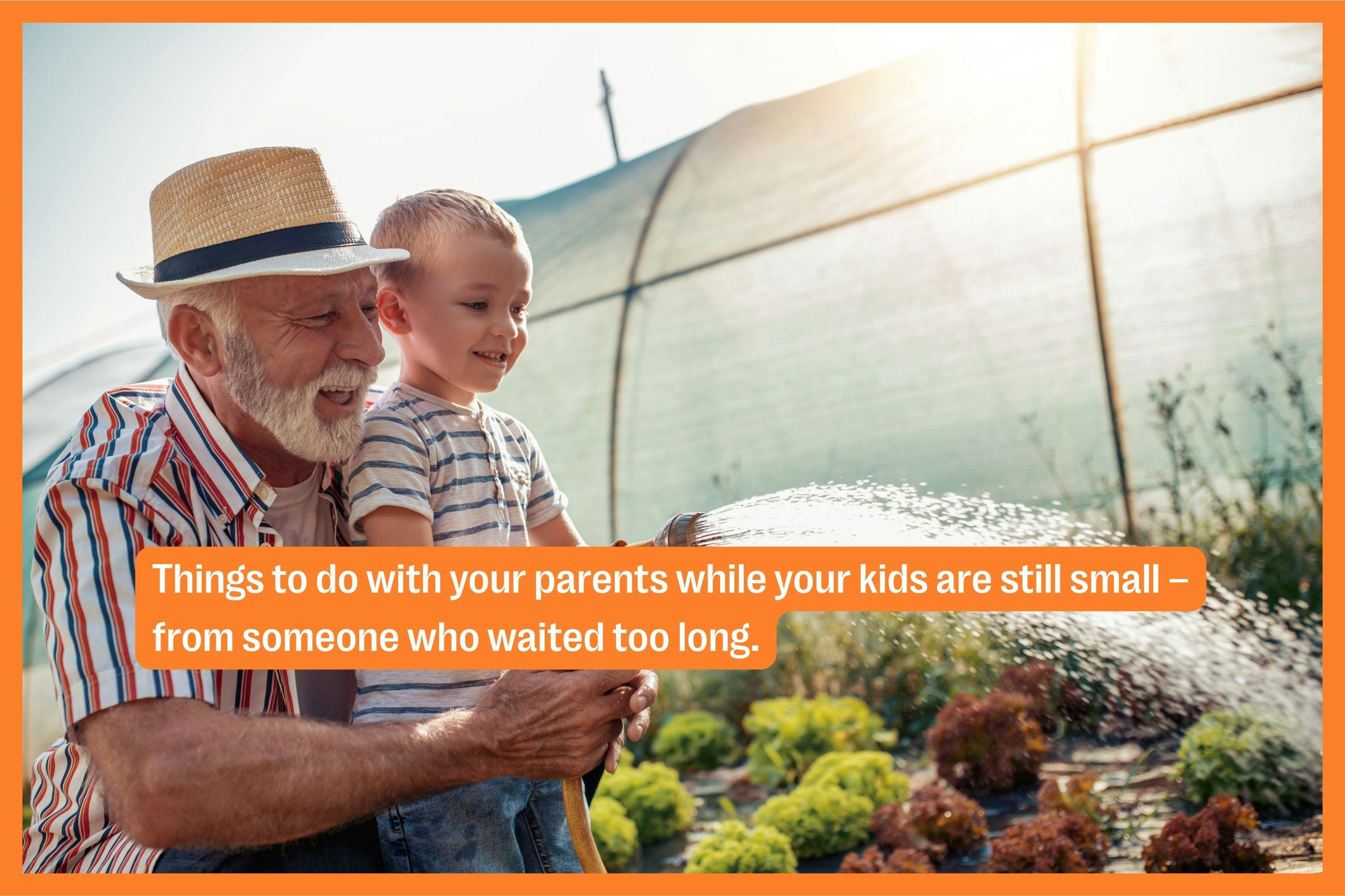 A grandfather and his grandson water the garden. 