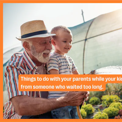A grandfather and his grandson water the garden.