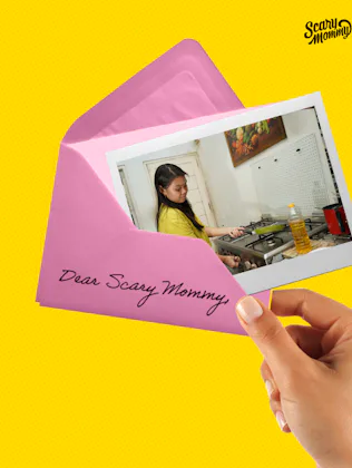 A woman holding a letter that says, "Ask Scary Mommy."