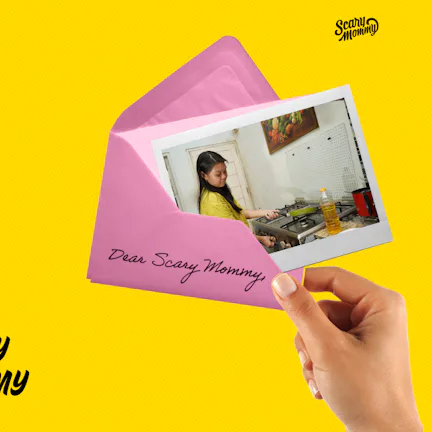 A woman holding a letter that says, "Ask Scary Mommy."